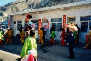 [59, 60] Informal street performances of Han folk dance in Ansai 安塞Township, Ansai 安塞county, Yan'an 延安. You can see the steep mountainside in the background of the picture. I traveled up the mountain the next day in order to see a marvelous performance of the Ansai Waist Drum Dance. Shaanxi Province 2003.